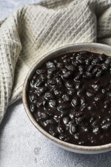 Instant Pot Cuban Black Beans in a bowl with a waffle knit napkin in the background