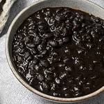 Instant Pot Black beans in a bowl with a waffle linen in the back