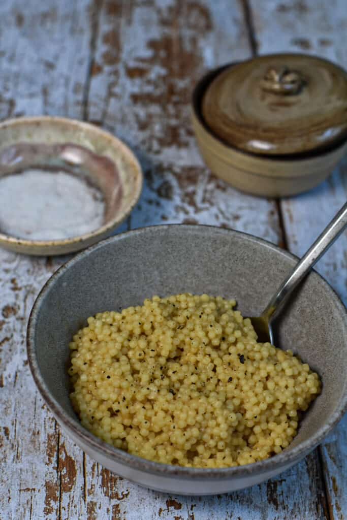 Comforting and Classic Pastina in a bowl with a pinch bowl of salt behind it