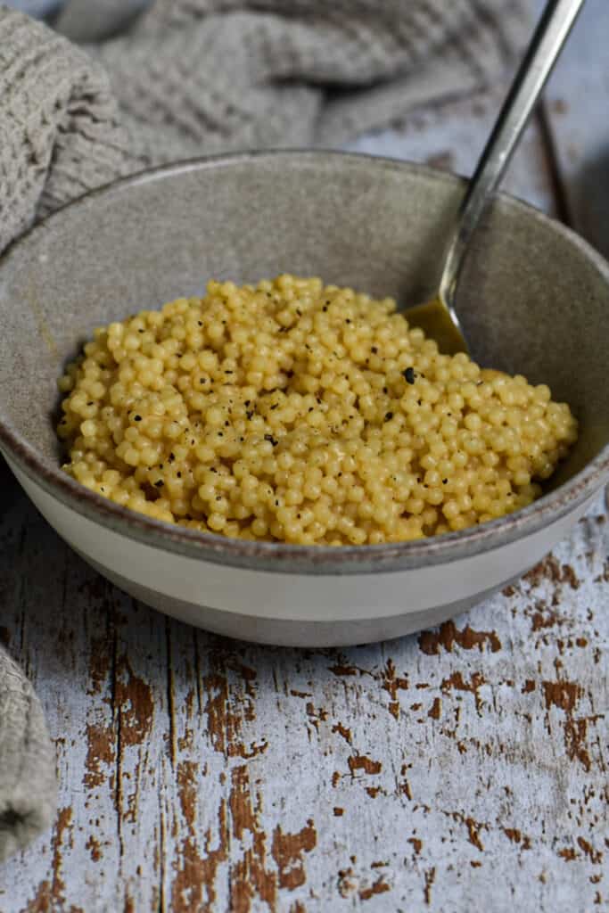 Comforting and Classic Pastina in a bowl with a beige towel behind it