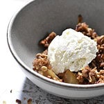 Cardamom Apple Crumble topped with vanilla bean ice cream in a grey bowl