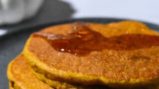 Stack of Healthy Pumpkin Pancakes with a drizzle of maple syrup