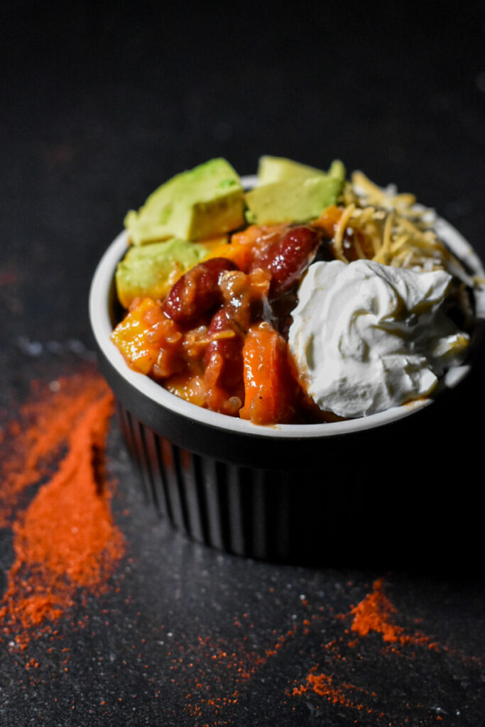 Sweet Potato Quinoa Chili topped with avocado, sour cream and cheese