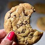 Bread Flour Chocolate Chip Cookie with a bite taken out of it, being help up.
