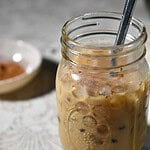 Pumpkin Iced Latte in a mason jar with a bowl of spices in teh background