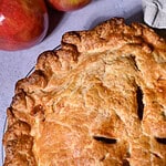 Classic Apple pie with two apples in the back