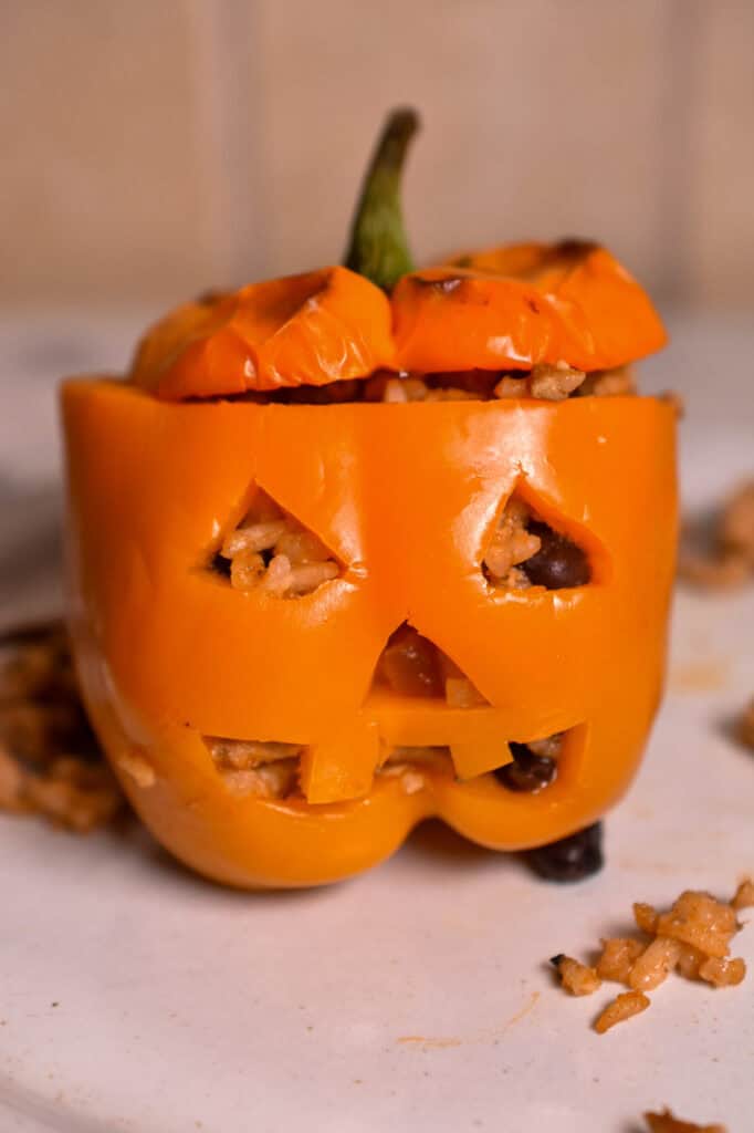 Halloween stuffed peppers carved into jack-o’-lanterns and filled with ground turkey, rice, black beans, and cheese